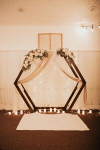 Elegant Hexagon Backdrop with Rose Gold Sequin Drape and Candles